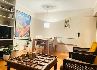 a living room with a table and a dining room at Apartman 23 in Kanarevo Brdo