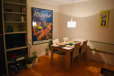 a dining room with a table with chairs and a tv at Apartman 23 in Kanarevo Brdo
