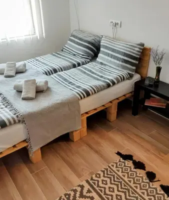 two beds sitting on top of a wooden floor at Le Petit Studio in Kanarevo Brdo