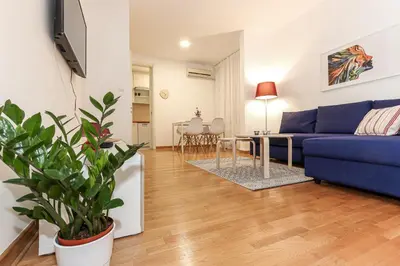 a living room with a blue couch and a table at Fortuna - cozy studio to relax Novi Beograd, parking 5 eur per day in Belgrade