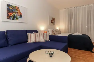 a living room with a blue couch and a bed at Fortuna - cozy studio to relax Novi Beograd, parking 5 eur per day in Belgrade