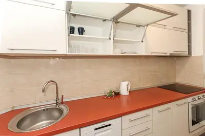 a kitchen with a sink and a red counter top at Fortuna - cozy studio to relax Novi Beograd, parking 5 eur per day in Belgrade