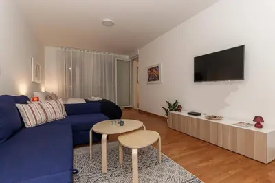 a living room with a blue couch and a table at Fortuna - cozy studio to relax Novi Beograd, parking 5 eur per day in Belgrade