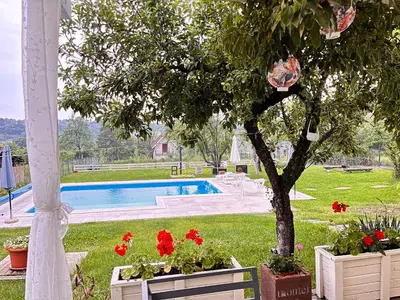 a garden with a pool and a tree and flowers at Vila blizu Beograda - My Family Cottage in Ba°evac