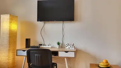 a desk with a chair and a television on a wall at Bulevar Plus in Belgrade