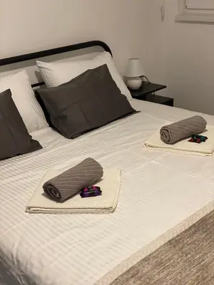 a bed with two towels and two pillows on it at Apartman Alexandra in Ruma