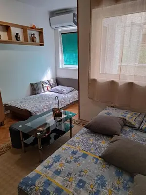 a living room with two beds and a table at Apartman Mirka 2 in Karaburma
