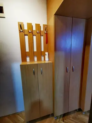 a locker room with a wooden cabinet next to a wall at Apartman Mirka 2 in Karaburma