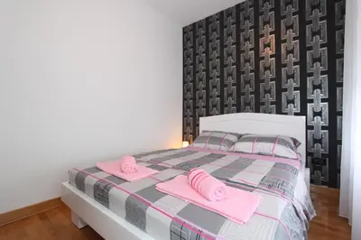 a bedroom with a bed with pink towels on it at Aleksandar - Stan Na dan Belvil Novi Beograd in Belgrade