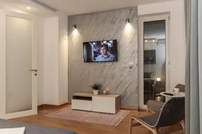 a living room with a tv on a wall at Portago - Stan na dan Belvil Novi Beograd in Belgrade