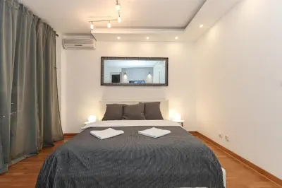 a bedroom with a large bed and a mirror at Portago - Stan na dan Belvil Novi Beograd in Belgrade