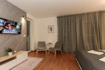 a hotel room with a bed and a tv on the wall at Portago - Stan na dan Belvil Novi Beograd in Belgrade