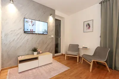 a living room with a tv on a wall at Portago - Stan na dan Belvil Novi Beograd in Belgrade