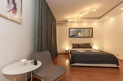 a bedroom with a bed and a table and chair at Portago - Stan na dan Belvil Novi Beograd in Belgrade
