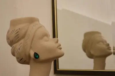 a statue of a head in front of a mirror at Golden Velvet apartment Belgrade in Belgrade