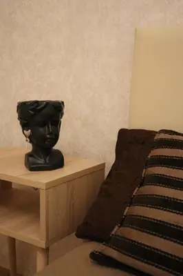 a black head statue on a nightstand next to a bed at Golden Velvet apartment Belgrade in Belgrade