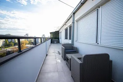 a balcony with two chairs on a building at Sunny Nest Apartment in Fontana