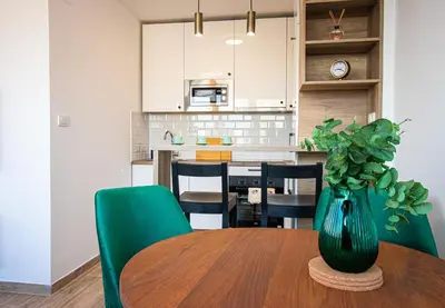 a dining room table with a green vase on it at Sunny Nest Apartment in Fontana