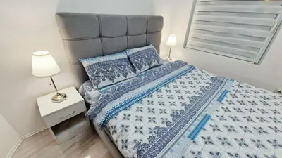 a bedroom with a bed with a blue and white comforter at Zeus in Zemun