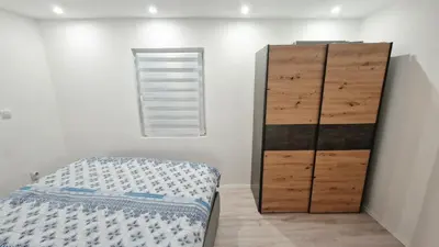 a bedroom with a bed and a wooden cabinet at Zeus in Zemun