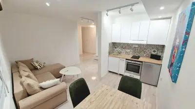 a kitchen and a living room with a couch and a table at Zeus in Zemun