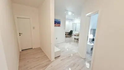 a white hallway with a mirror and a dining room at Zeus in Zemun