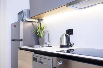 a kitchen with a sink and a refrigerator at Belgrade Waterfront Cozy Symphony 1 in Sajmište