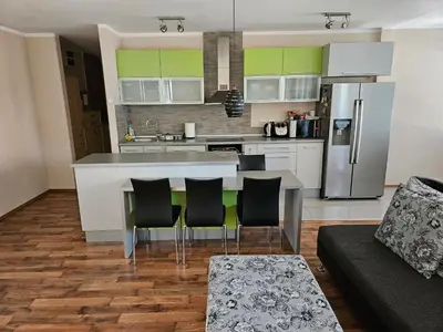 a kitchen and living room with a table and chairs at Hawaii- 2 bdr, Arena, Sava centar, FREE PARKING in Novi Beograd