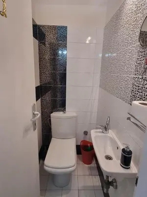 a white bathroom with a toilet and a sink at Hawaii- 2 bdr, Arena, Sava centar, FREE PARKING in Novi Beograd