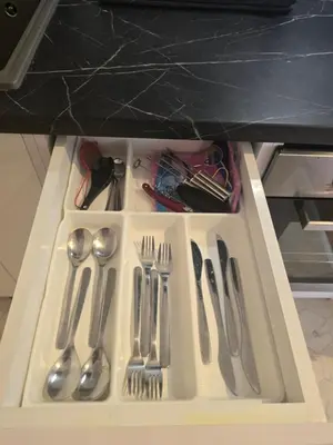 a drawer filled with silver utensils on a shelf at Apartman Stepa K3 in Belgrade