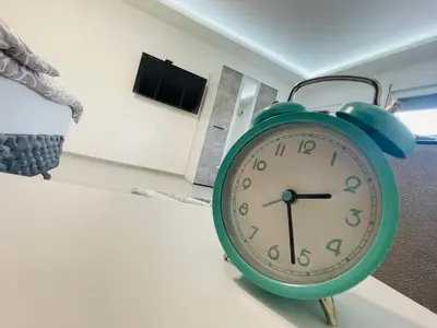 a green clock sitting on a table in a room at Luxury Centar 2 in Arandjelovac