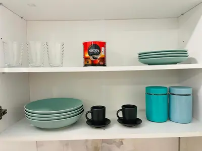 a shelf with a toilet and plates and cups at Luxury Centar 2 in Arandjelovac