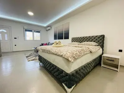 a bedroom with a large bed with a large headboard at Luxury Centar 2 in Arandjelovac