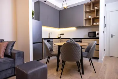 a kitchen and dining room with a table and chairs at Belgrade Waterfront Cozy Symphony 2 in Sajmište