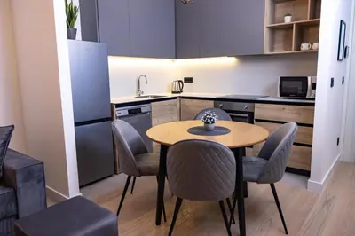 a kitchen with a table and chairs in a room at Belgrade Waterfront Cozy Symphony 2 in Sajmište