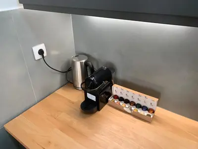 a coffee machine sitting on top of a wooden table at Apartment Grau in Žarkovo