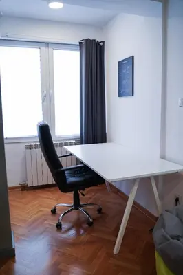 an office with a white desk and a black chair at Apartment Grau in Žarkovo