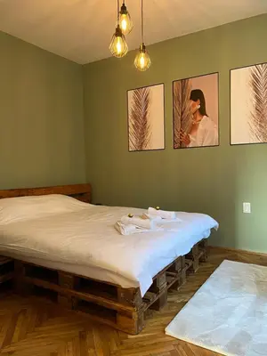 a large bed in a room with paintings on the wall at Under the Pine in Belgrade