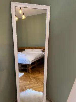 a mirror in a bedroom with a bed in it at Under the Pine in Belgrade