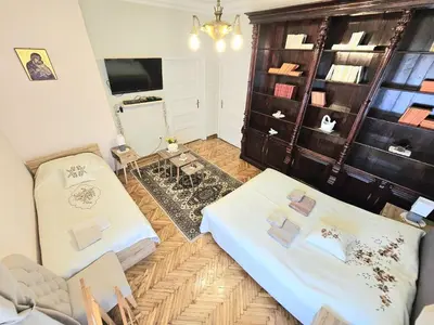 a living room with two beds and a tv at Apartman Didi in Belgrade