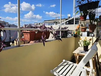 a white chair sitting on a balcony with plants at Apartman Didi in Belgrade