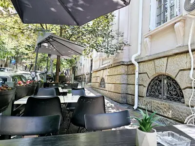 a restaurant with tables and chairs and an umbrella at Apartman Didi in Belgrade