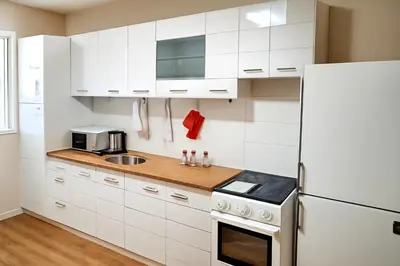 a kitchen with white cabinets and a white refrigerator at Apartman Beograd Banovo Brdo - lux dvosoban stan in Belgrade