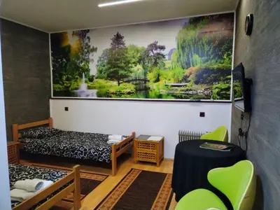 a room with two beds and a painting on the wall at FUN ROOMS SOBE PRENOĆIŠTE in Borča