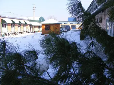 a snow covered street with a building and a tree at FUN ROOMS SOBE PRENOĆIŠTE in Borča