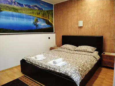 a bedroom with a bed with a painting on the wall at FUN ROOMS SOBE PRENOĆIŠTE in Borča