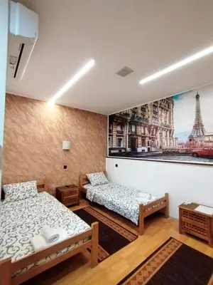 a room with two beds and a picture of the eiffel tower at FUN ROOMS SOBE PRENOĆIŠTE in Borča
