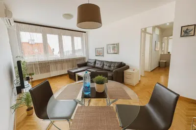 a living room with a table and chairs and a couch at ART residence Cara Urosa in Belgrade
