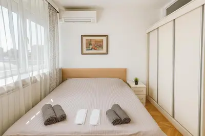 a bedroom with a bed with two slippers on it at ART residence Cara Urosa in Belgrade