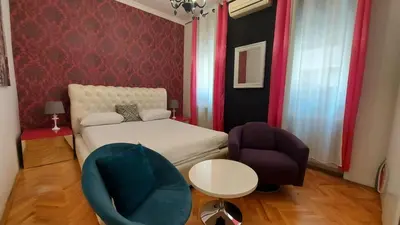 a small bedroom with a bed and a chair at TITO in Belgrade